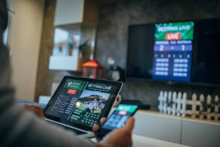 One senior man watches soccer match and bets on the game.
